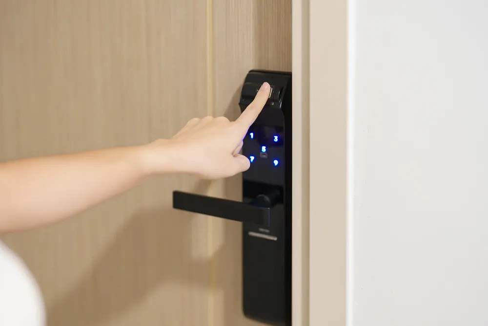 Foto de una mujer abriendo la puerta de su suite con su huella gracias a las soluciones de acceso de Bama