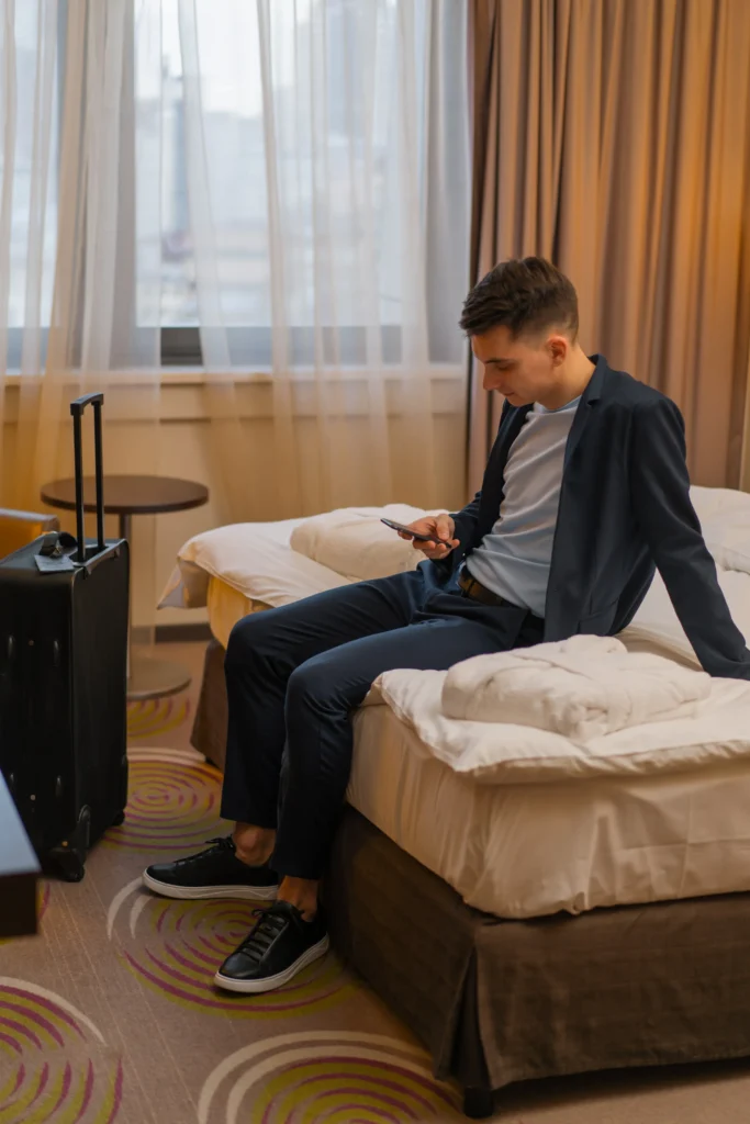 Fotografía a un joven viajero en su habitación estándar, uno de los tipos de habitaciones de un hotel