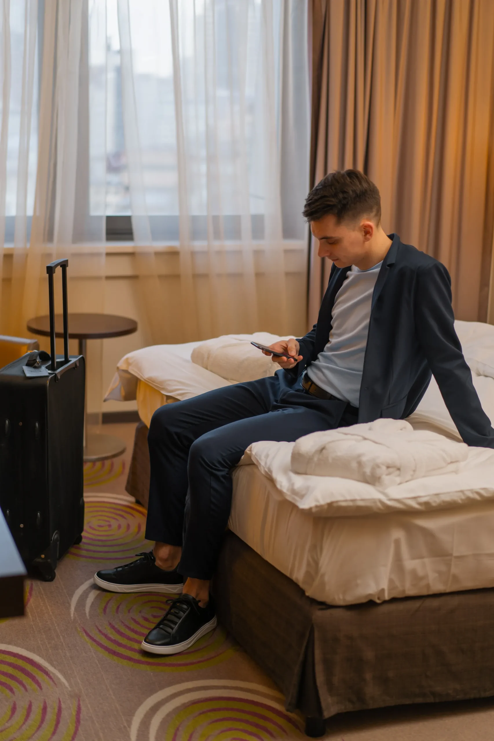 Fotografía a un joven viajero en su habitación estándar, uno de los tipos de habitaciones de un hotel